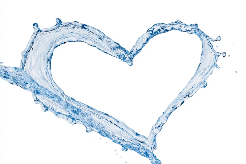 Water splash forming a heart shape against white background