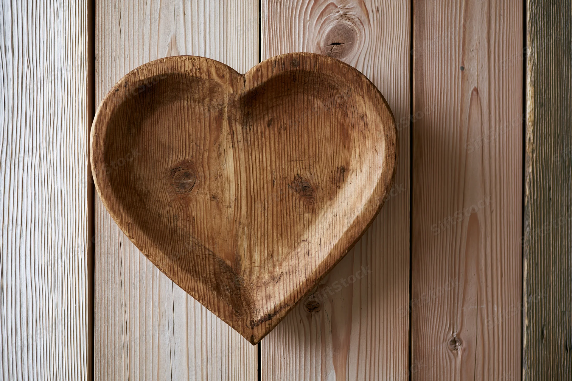 Heart-shaped wooden tray resting on vertical pine planks