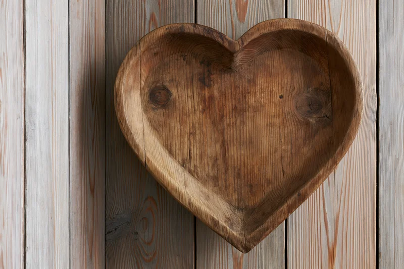 Heart-shaped wooden tray resting on vertical pine planks