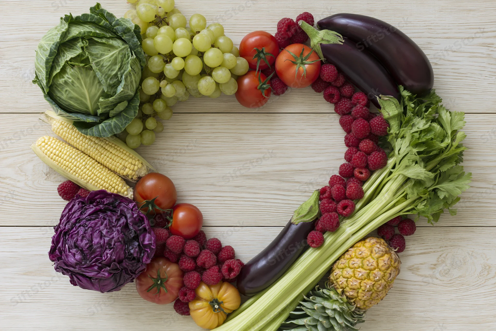 Heart-shaped arrangement of fresh fruits and vegetables on wooden surface