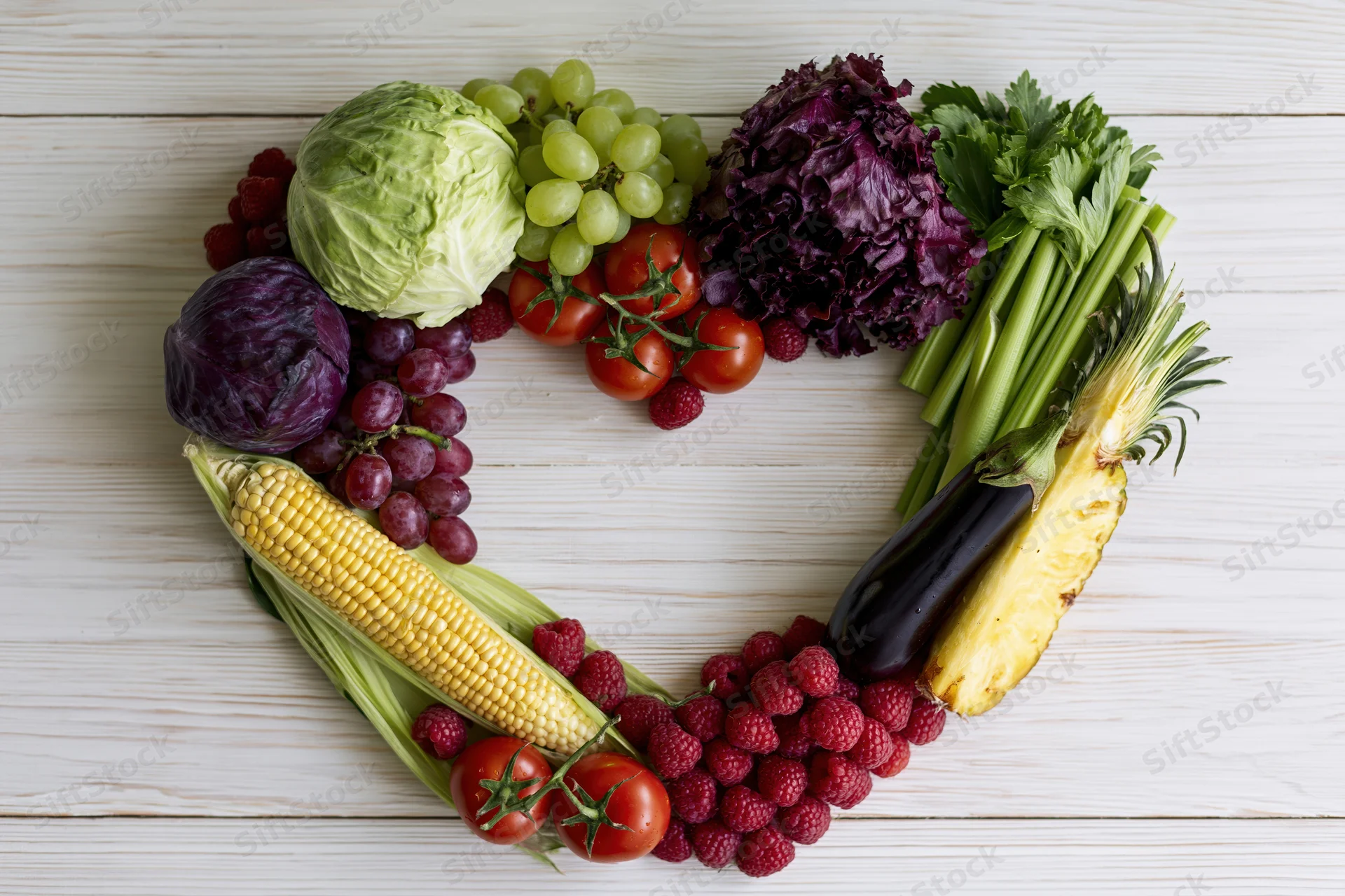 Heart-shaped arrangement of fresh fruits and vegetables on wooden surface