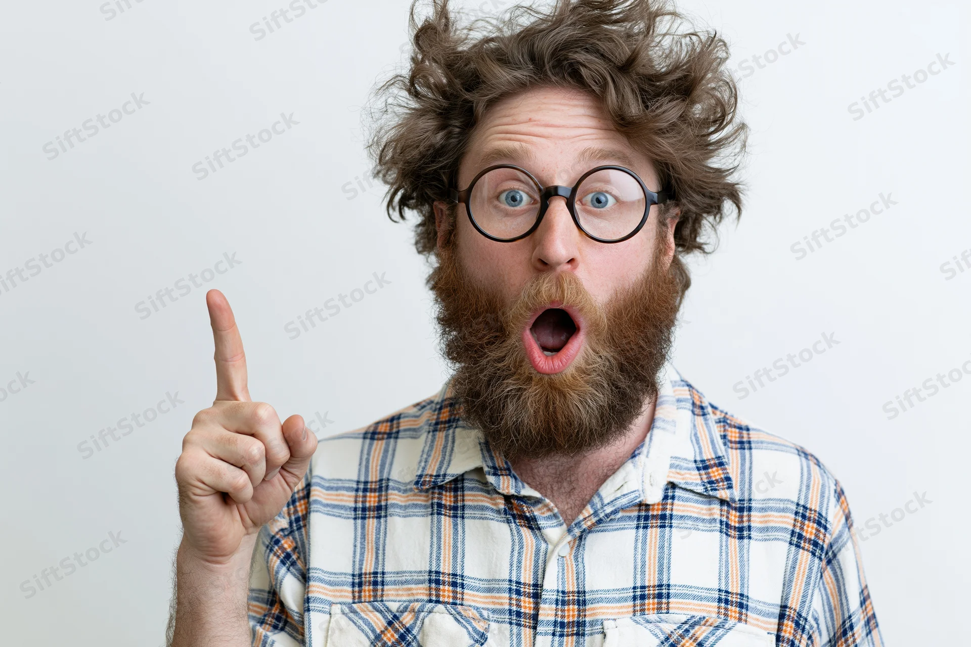 Bearded man with wild curly hair and round glasses pointing upward in surprise against white background