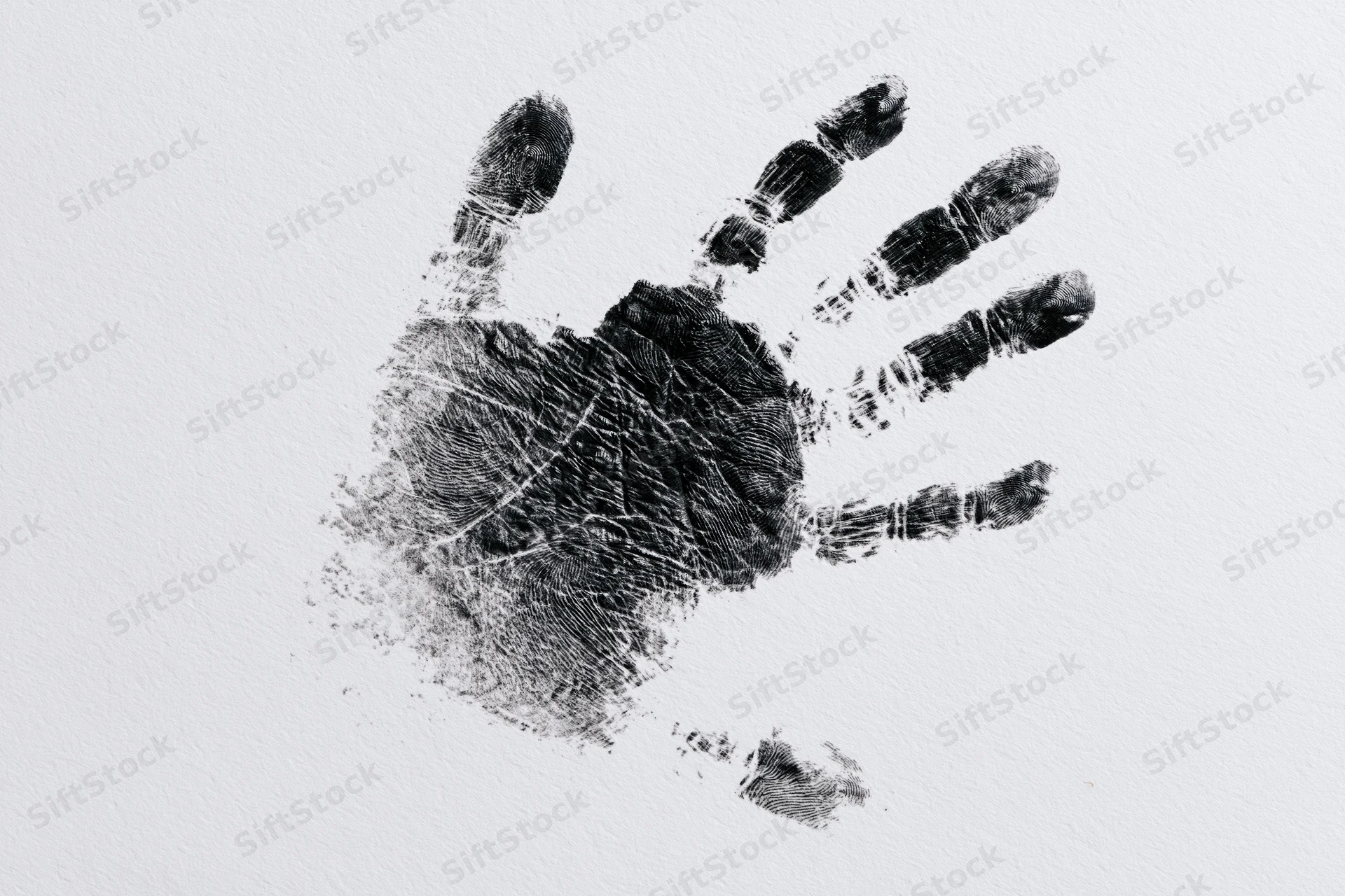 Black ink handprint of a child pressed onto white paper