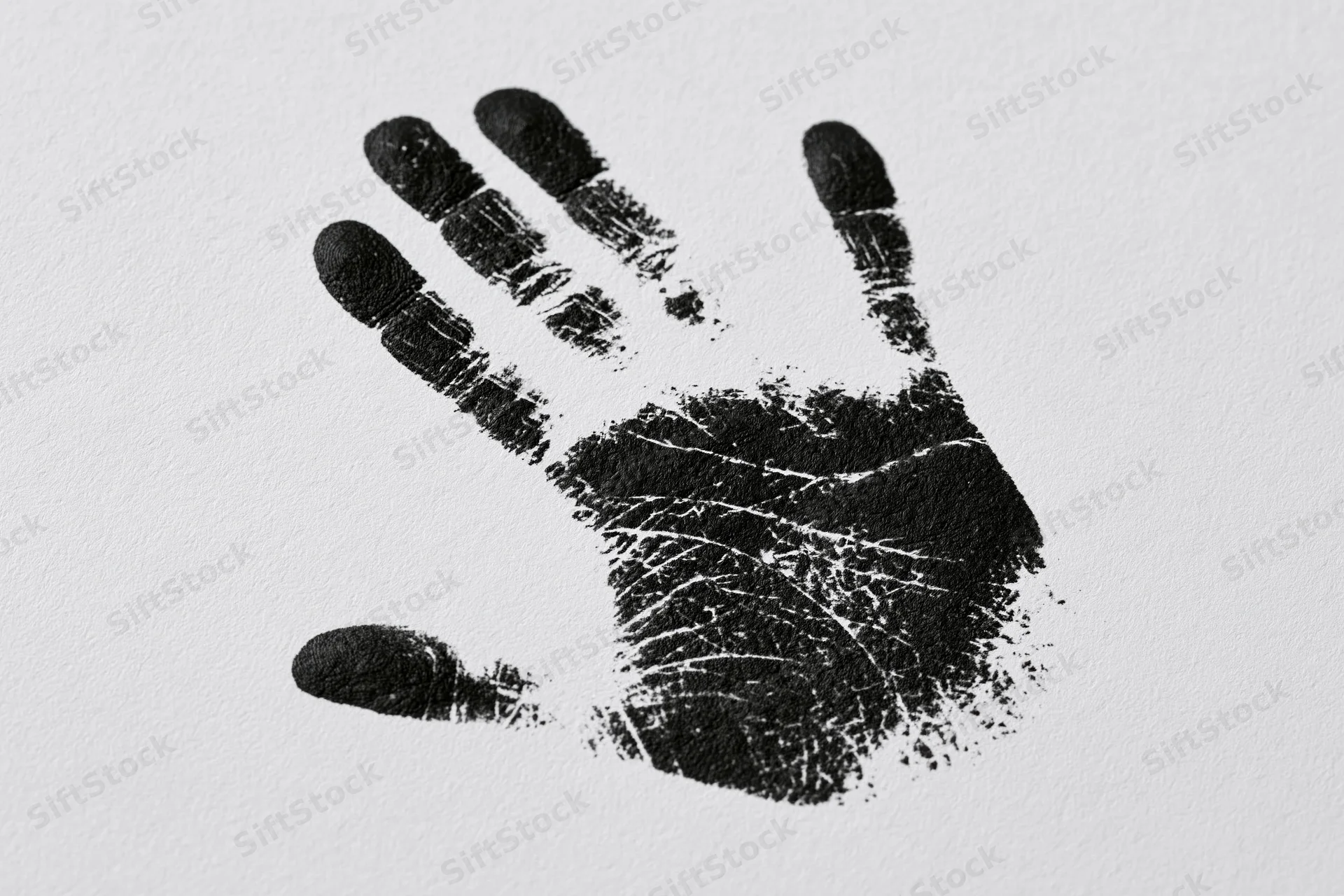 Black ink handprint stamped on white paper showing fingers and palm