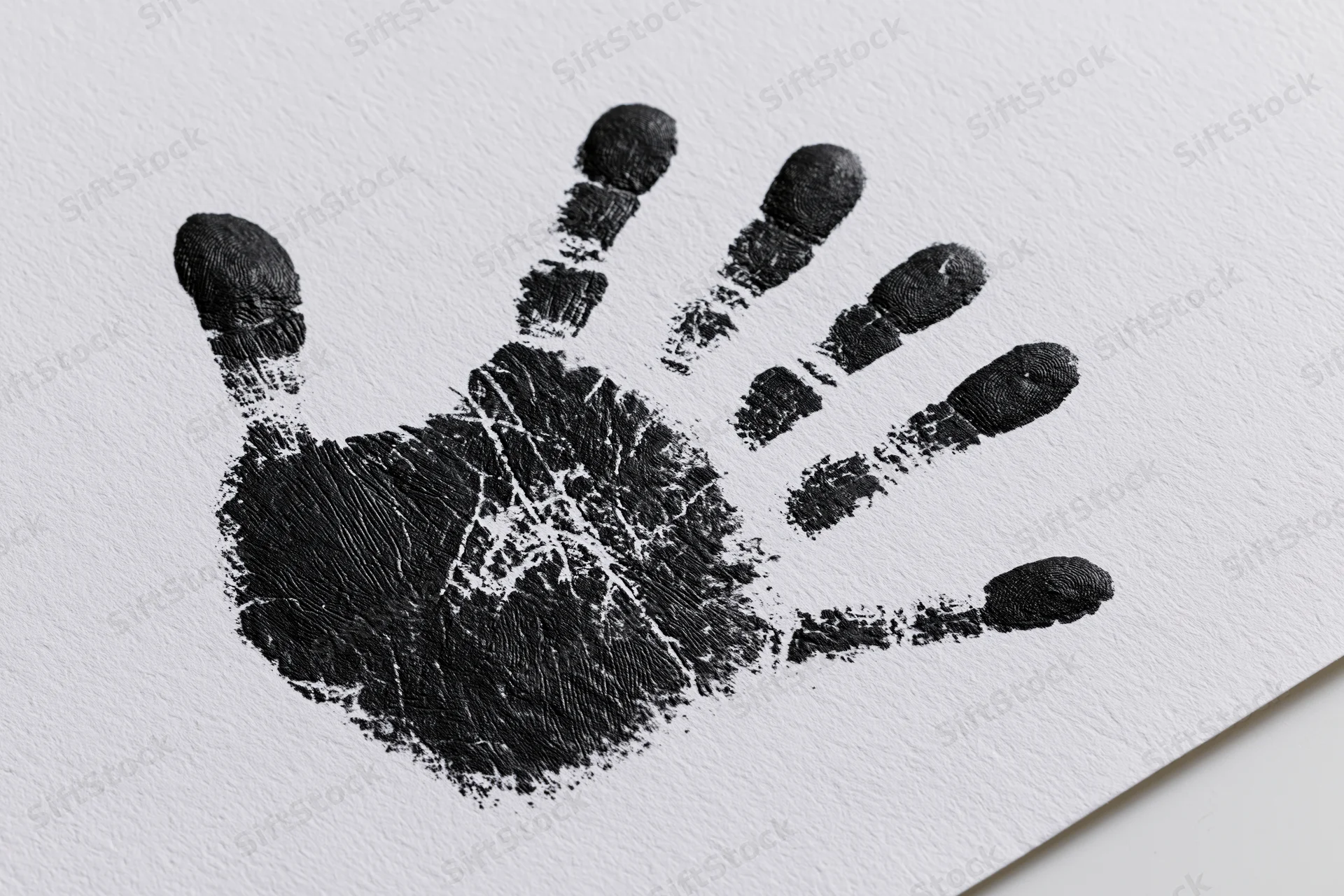 Black ink handprint stamped on textured white paper with visible fingerprints and palm details