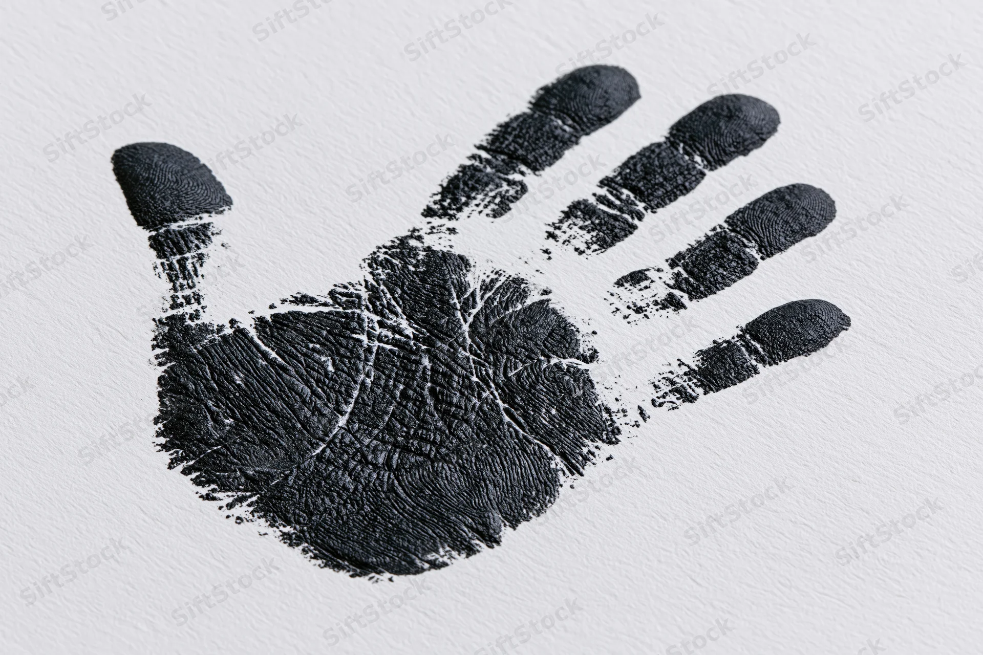 Black ink handprint stamped on white textured paper showing detailed fingerprints and palm lines