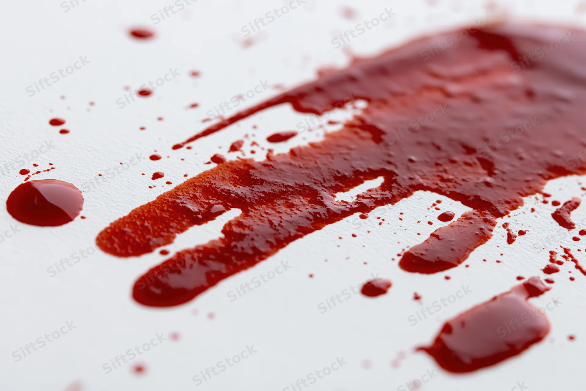 Blood splatter and drip marks on a white surface