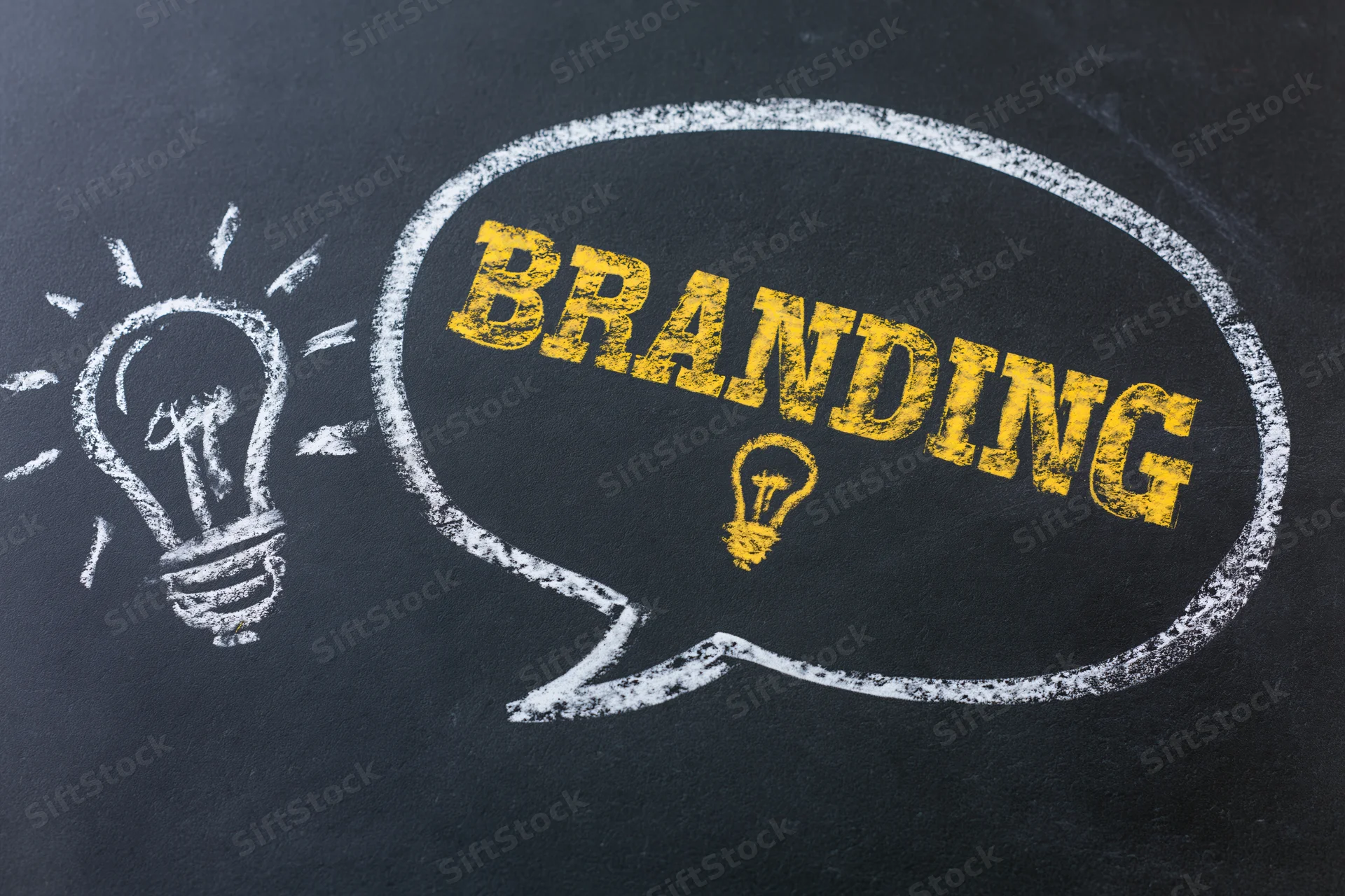 Chalk drawing of a speech bubble with the word branding and a lightbulb on a blackboard
