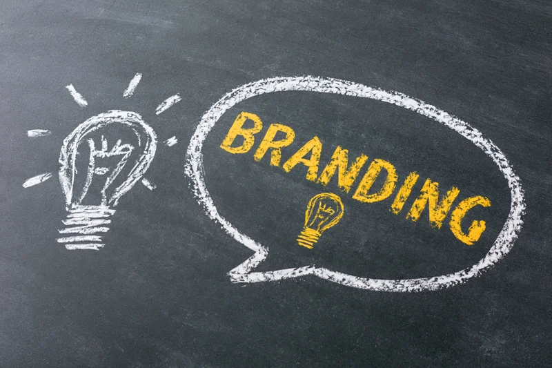 Chalk drawing of a lightbulb and speech bubble with the word branding on a blackboard
