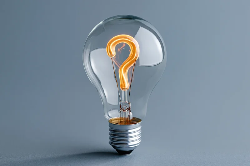 Clear glass incandescent light bulb with glowing orange question mark filament on gray background