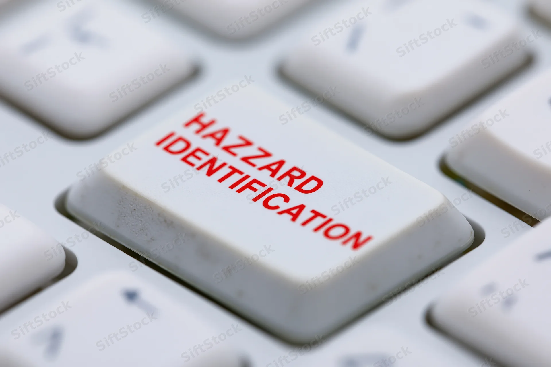 Close-up of a white keyboard key labeled hazard identification in red text