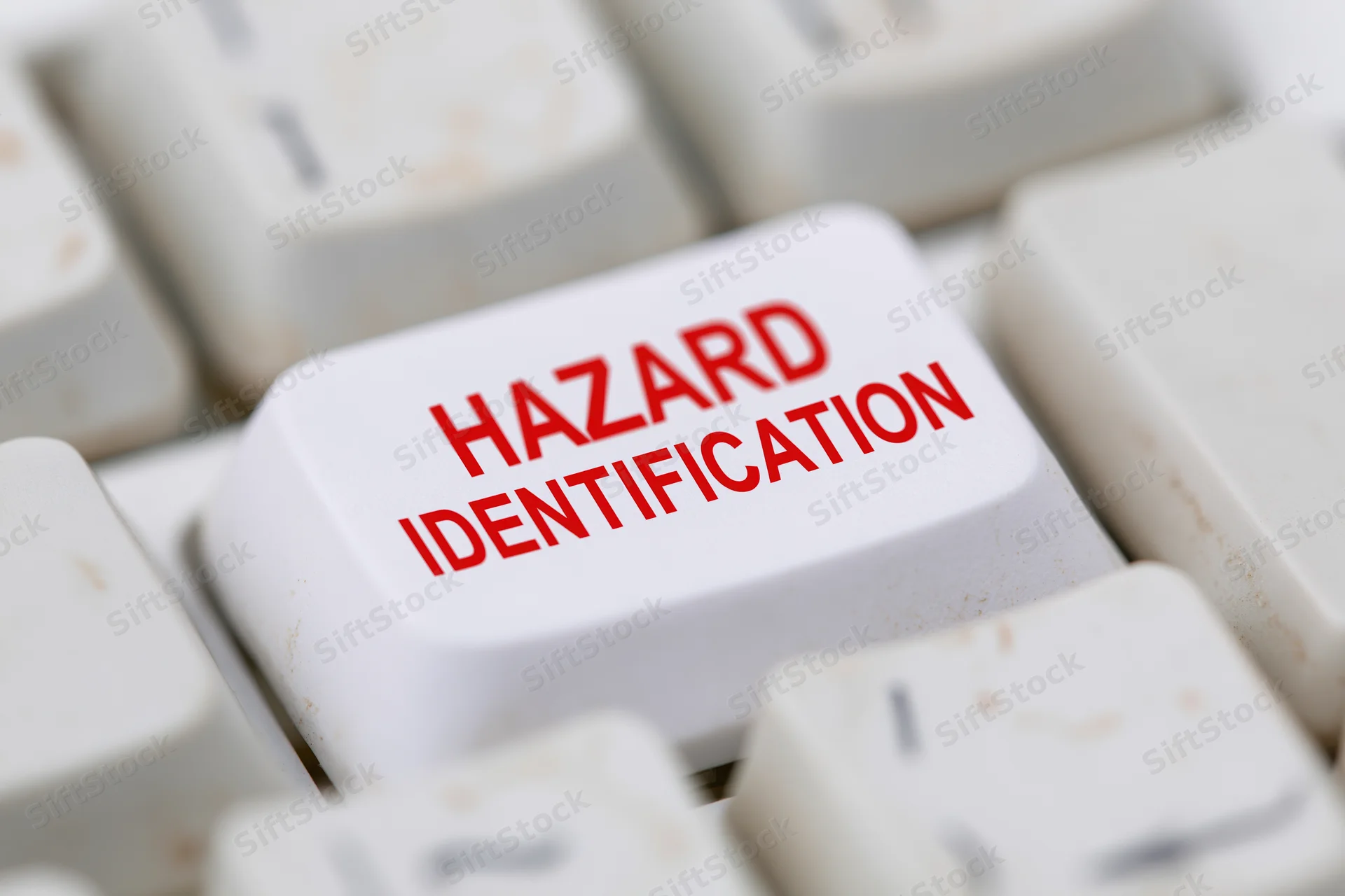 Close-up of a white keyboard key labeled hazard identification in red text