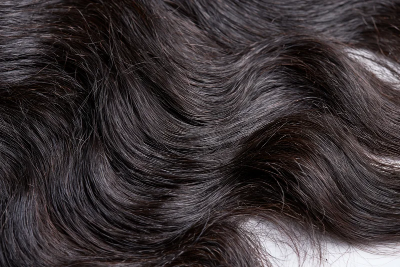 Close-up of dark wavy human hair extensions showing texture and shine