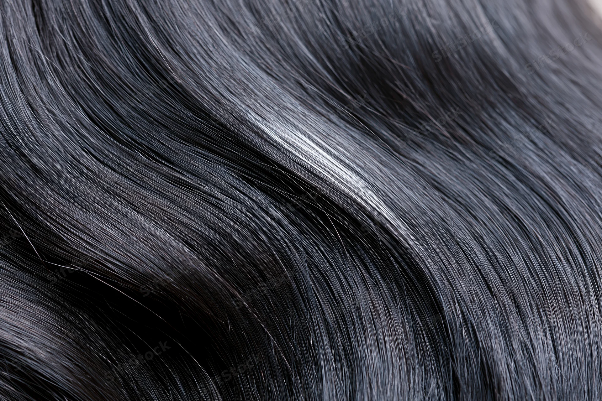 Close-up of glossy dark black hair strands with natural sheen