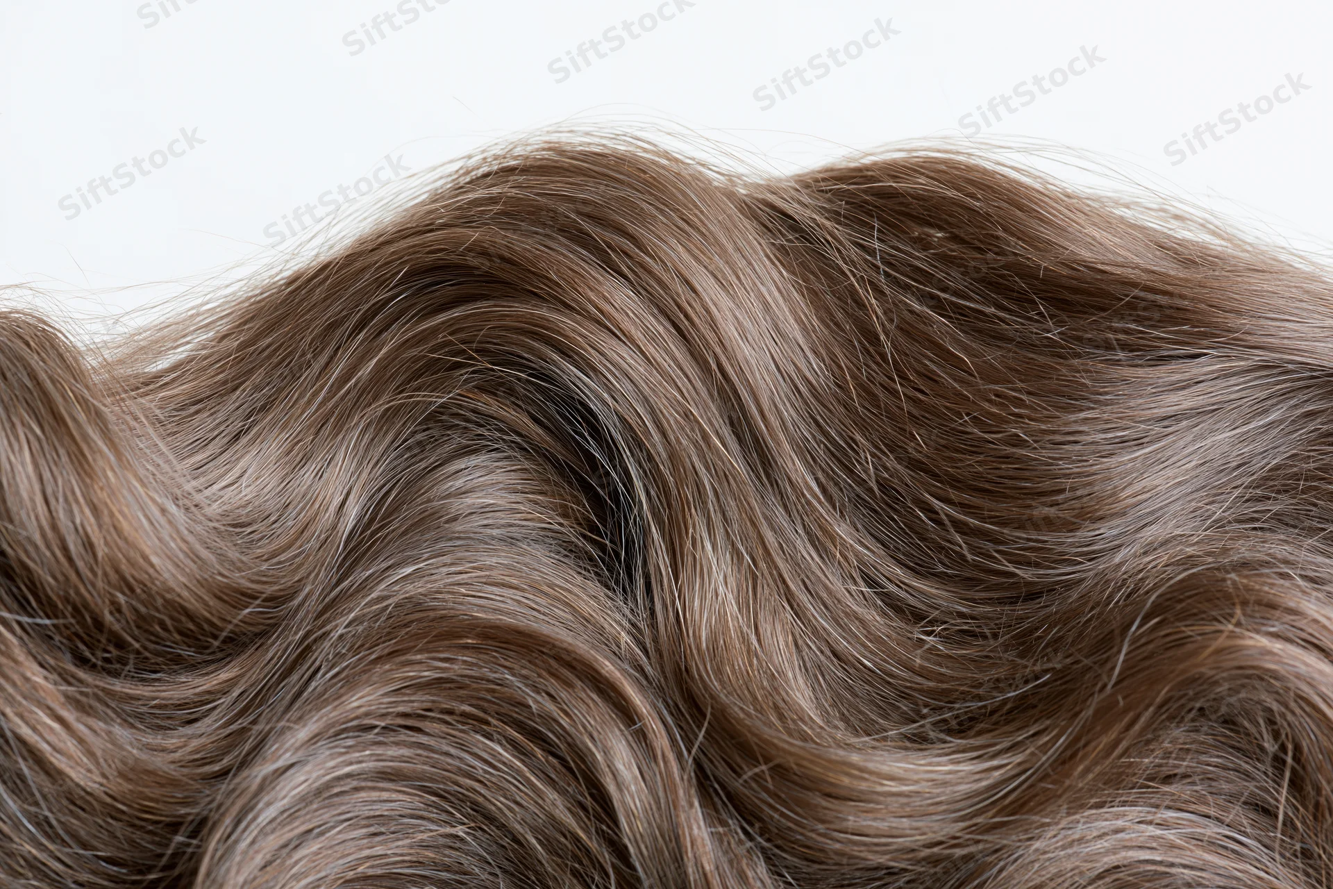 Close-up of loose wavy brown hair strands arranged in soft flowing texture