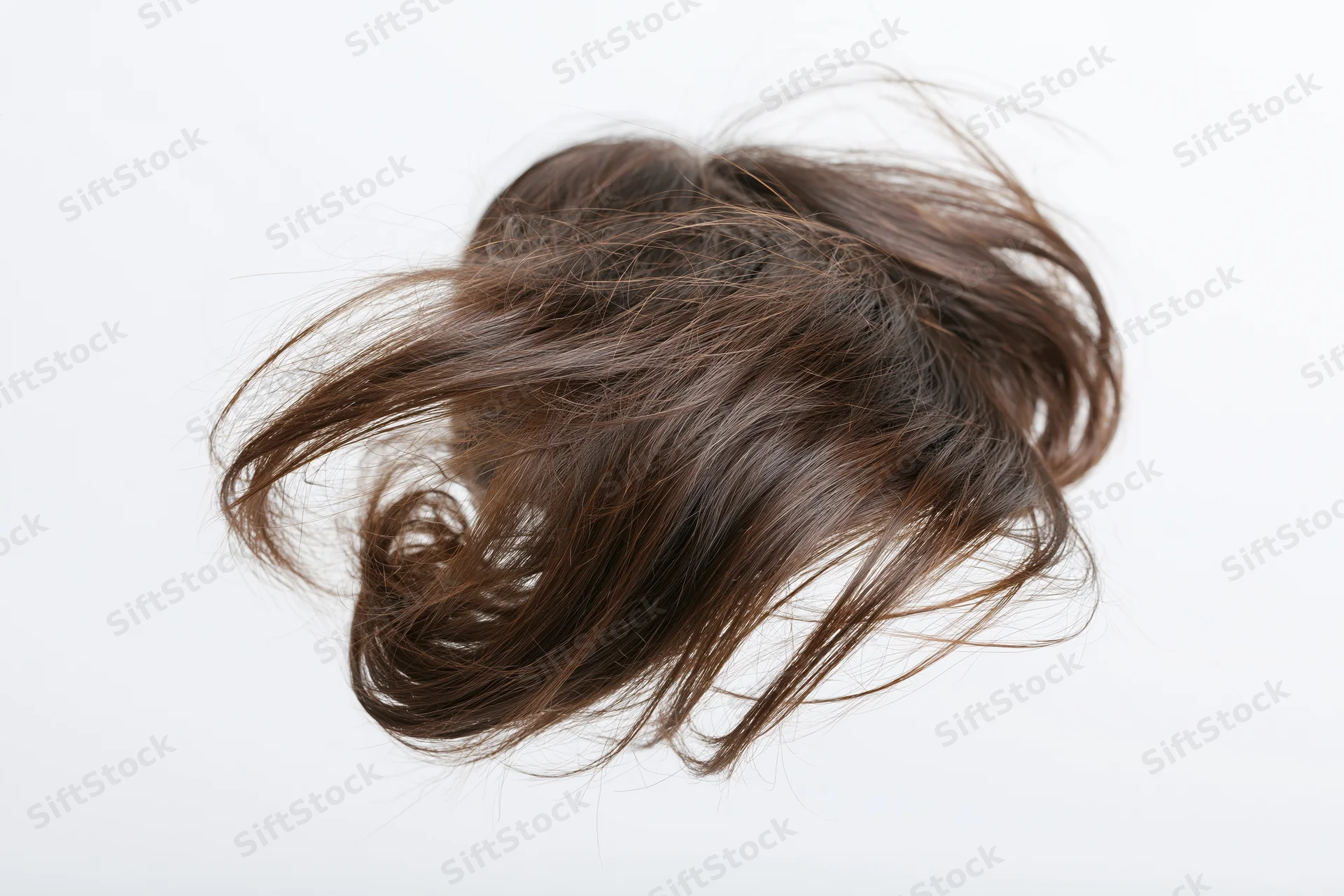 Dark brown human hair frozen mid-toss against white background