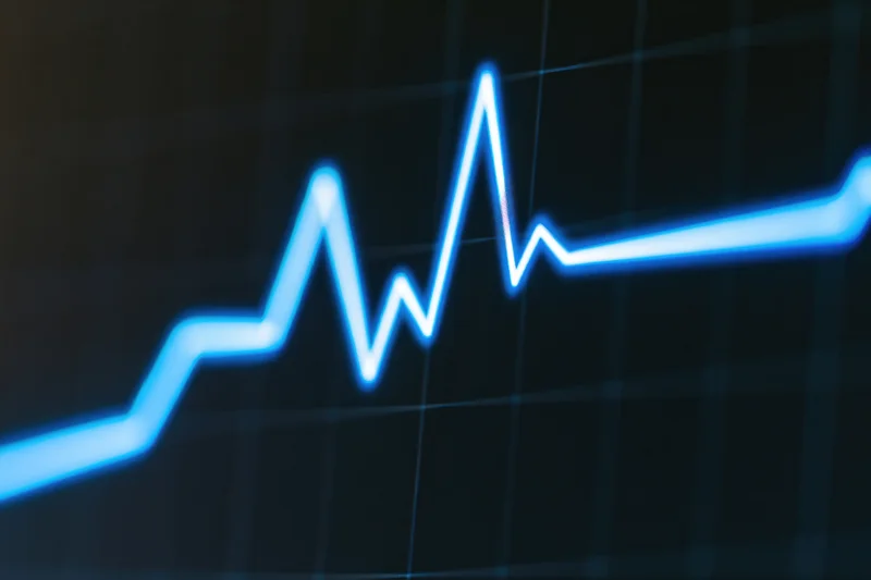 Glowing blue ecg waveform on a dark medical monitor screen