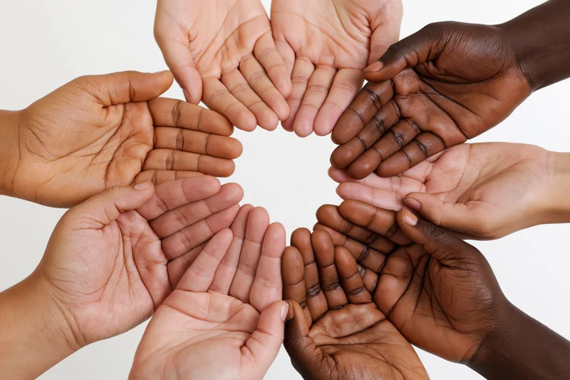 Diverse hands joined in a circle against a white background