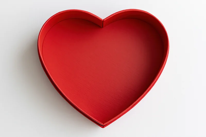 Red heart-shaped gift box lid on white surface with copyspace