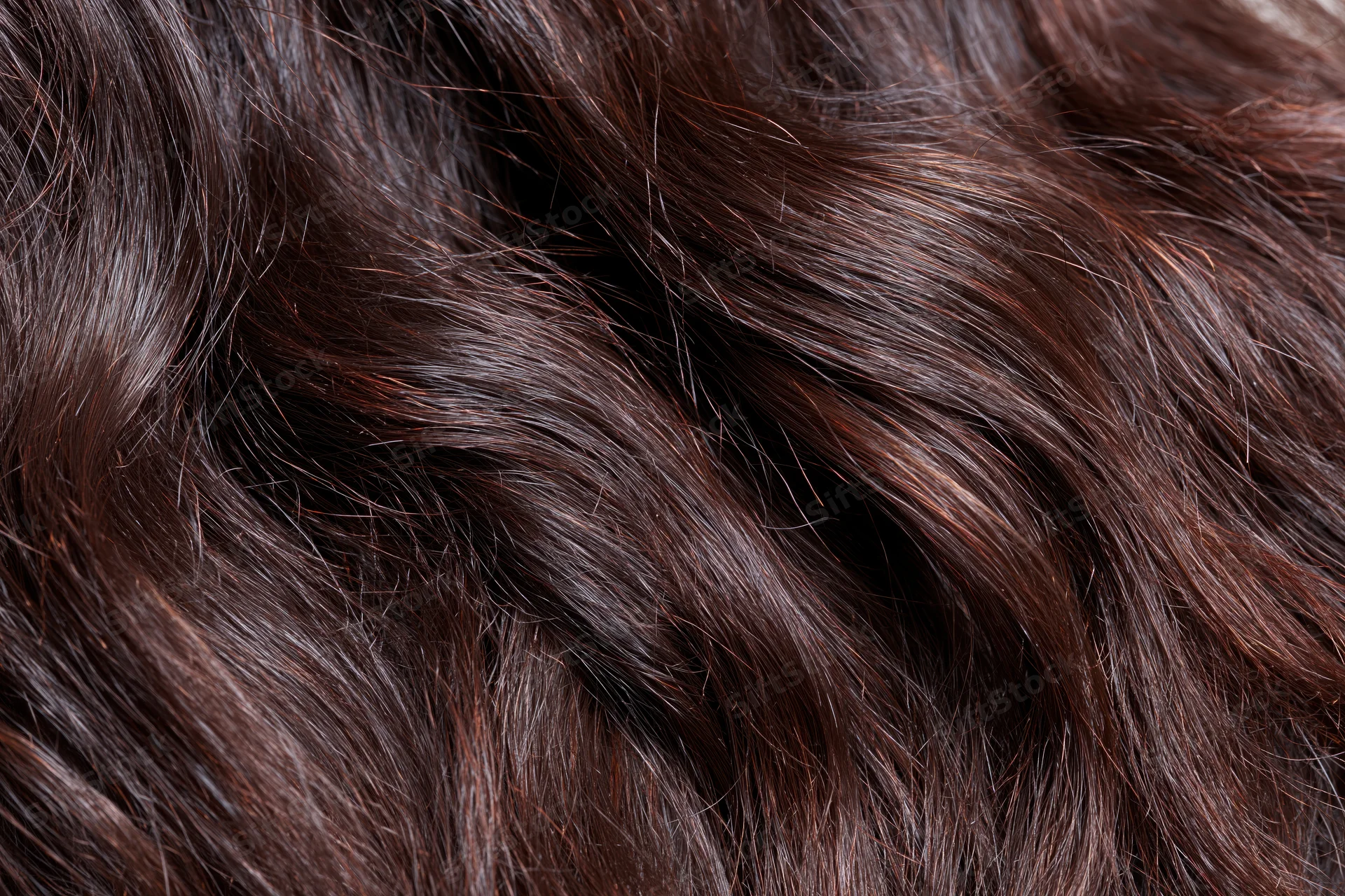 Extreme close-up of dark brown wavy hair showing texture and shine