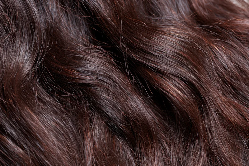 Extreme close-up of dark brown wavy hair showing texture and shine