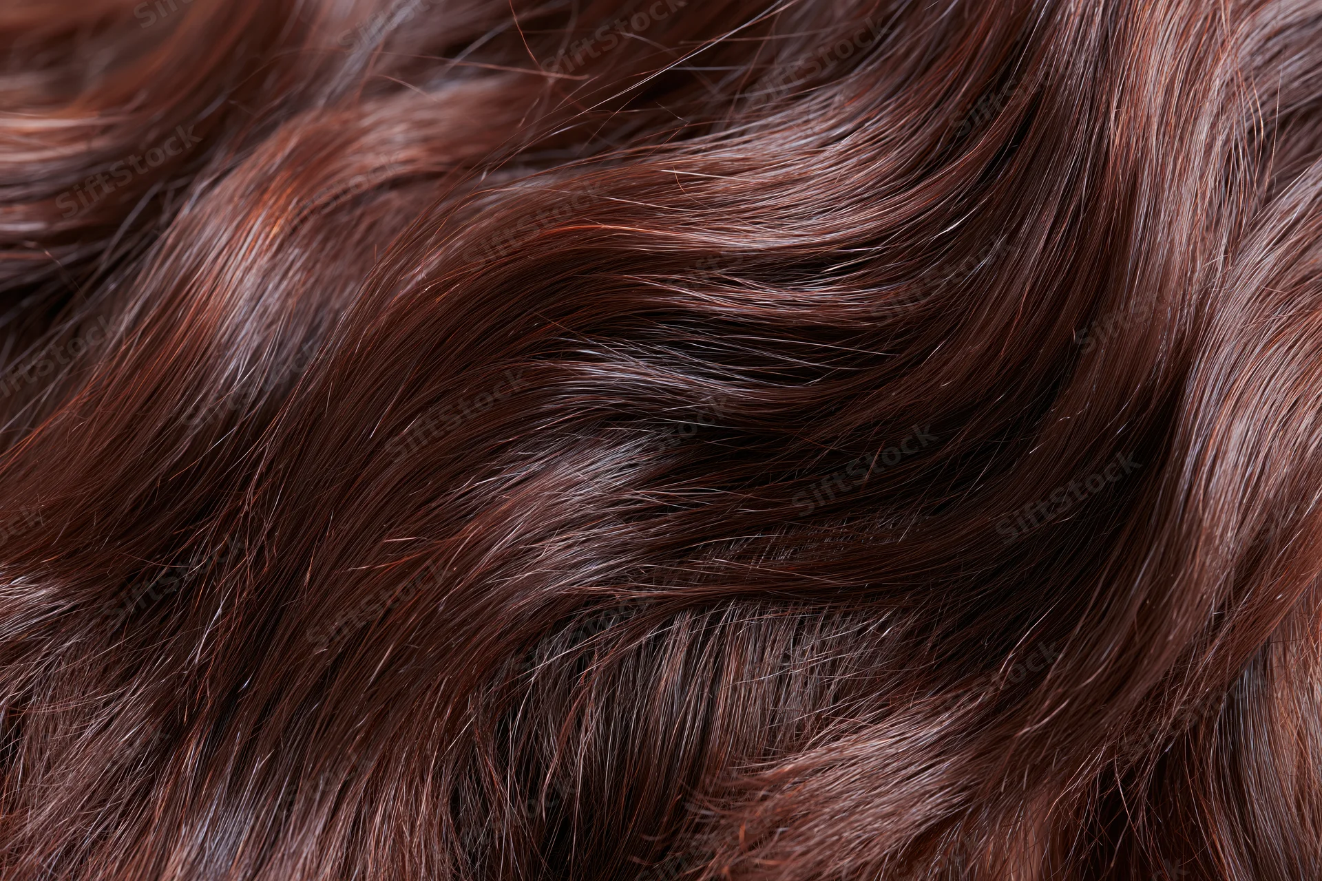 Closeup of dark brown wavy hair showing glossy texture and natural flow