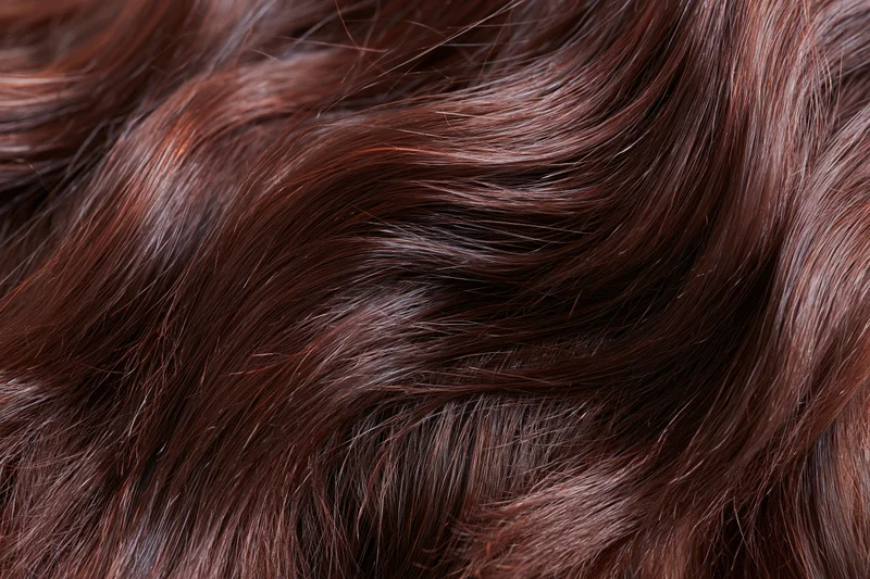 Closeup of dark brown wavy hair showing glossy texture and natural flow