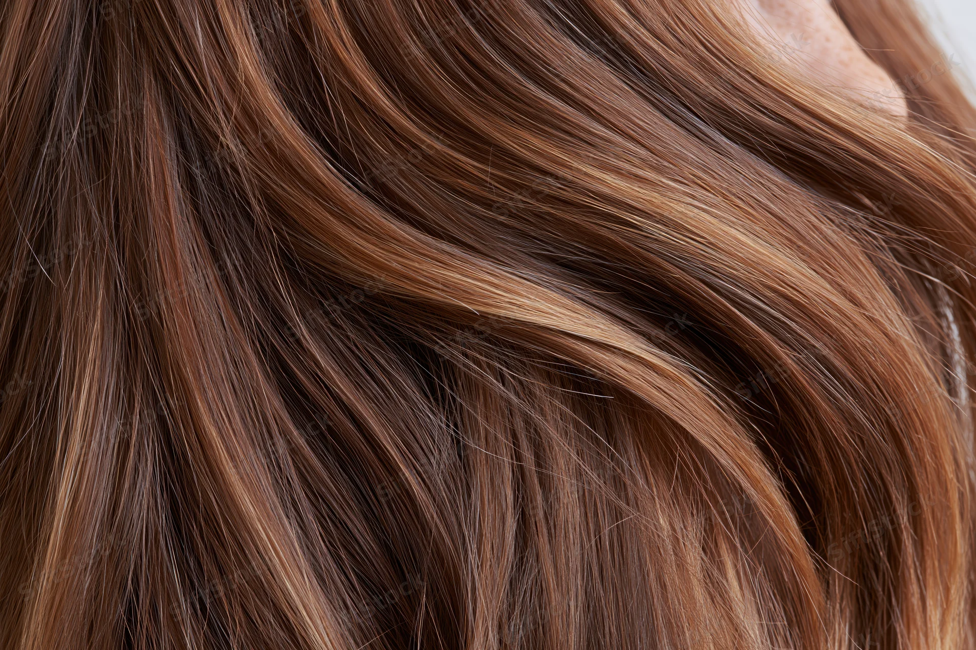 Closeup of flowing medium-brown hair with highlights and waves