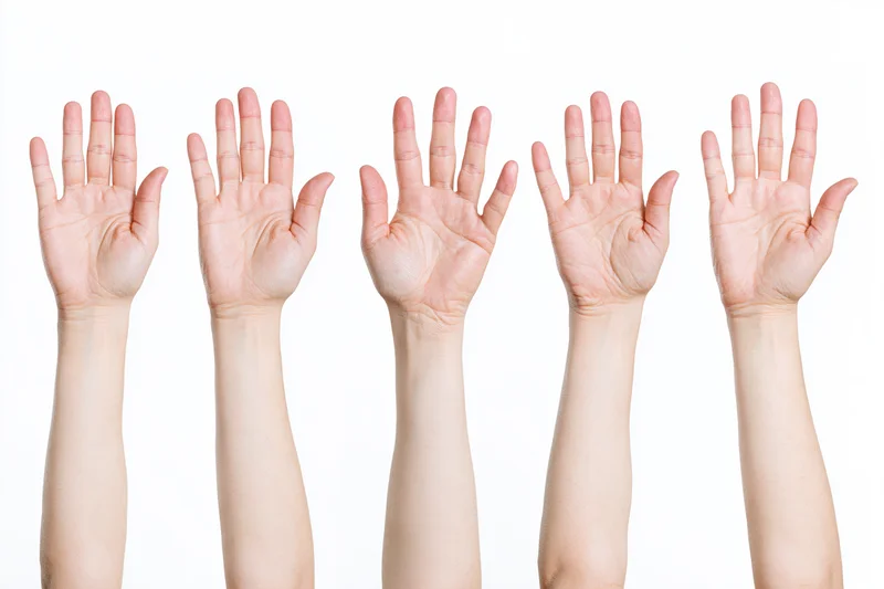 Five female hands raised with palms facing forward against a white background