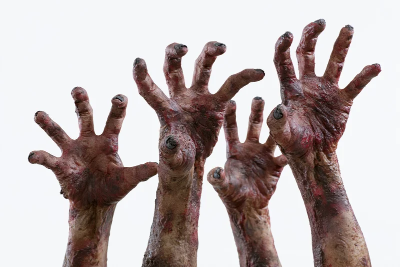 Zombie hands reaching upward with clawed fingers against white background