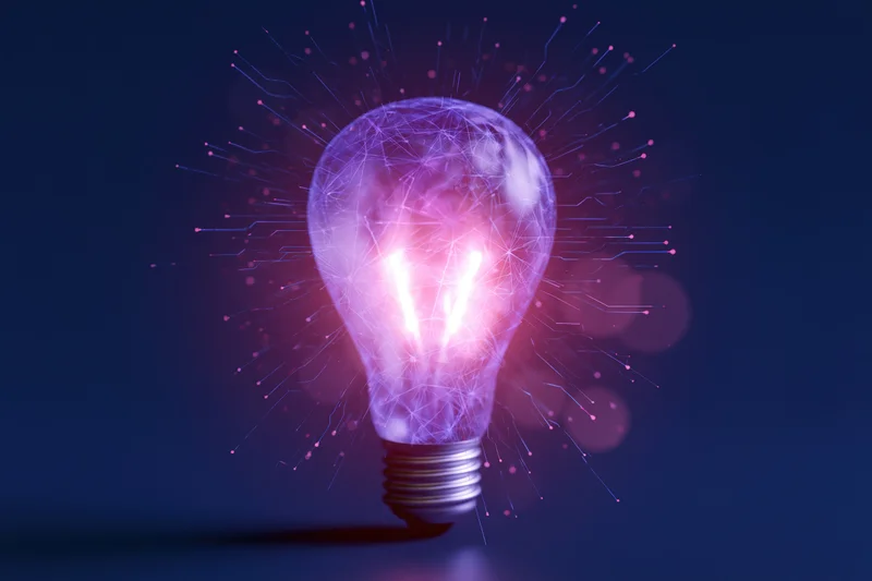 Glowing glass lightbulb with digital circuit patterns on dark purple background