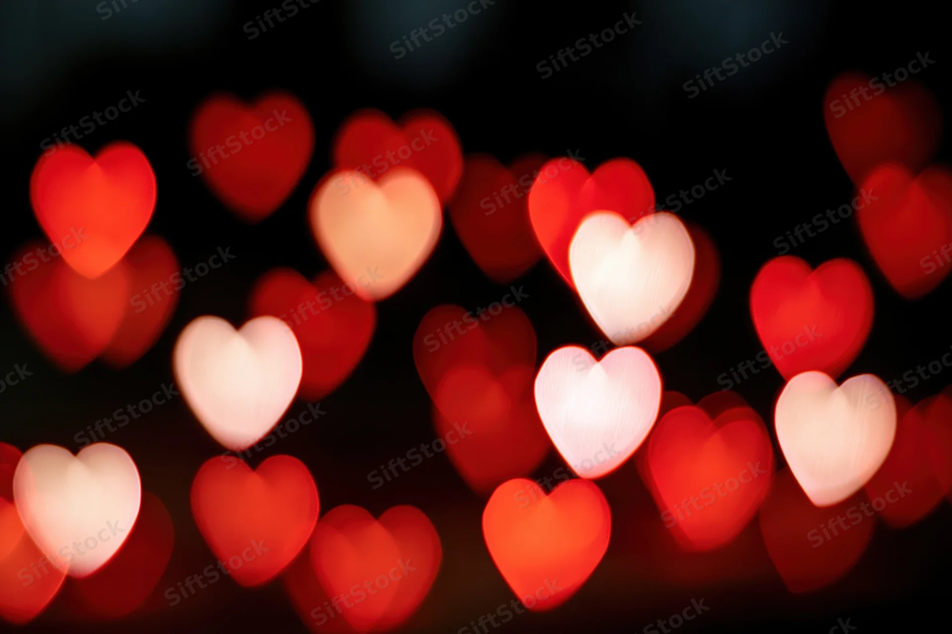 Heart-shaped bokeh lights glowing softly against a dark background