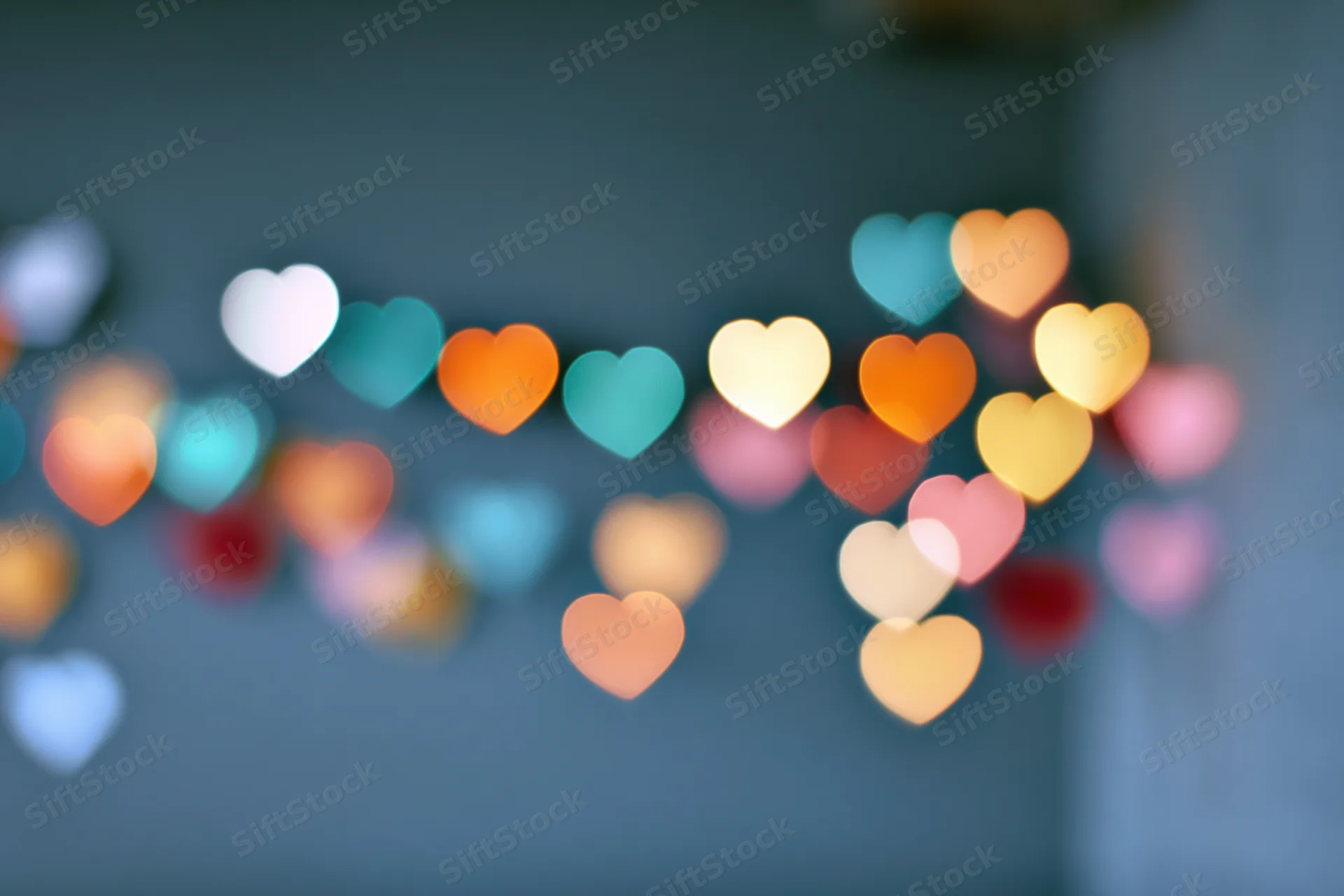 Heart-shaped bokeh lights scattered across frame in soft focus against dark background
