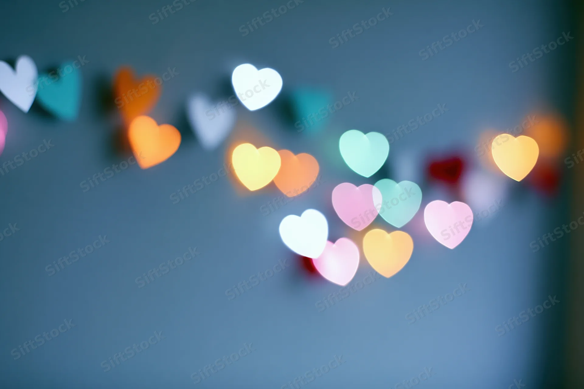 Heart-shaped bokeh lights scattered across a blurred blue background