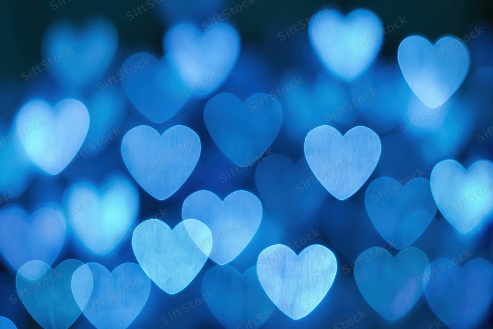 Heart-shaped bokeh lights scattered across the frame in soft blue glow