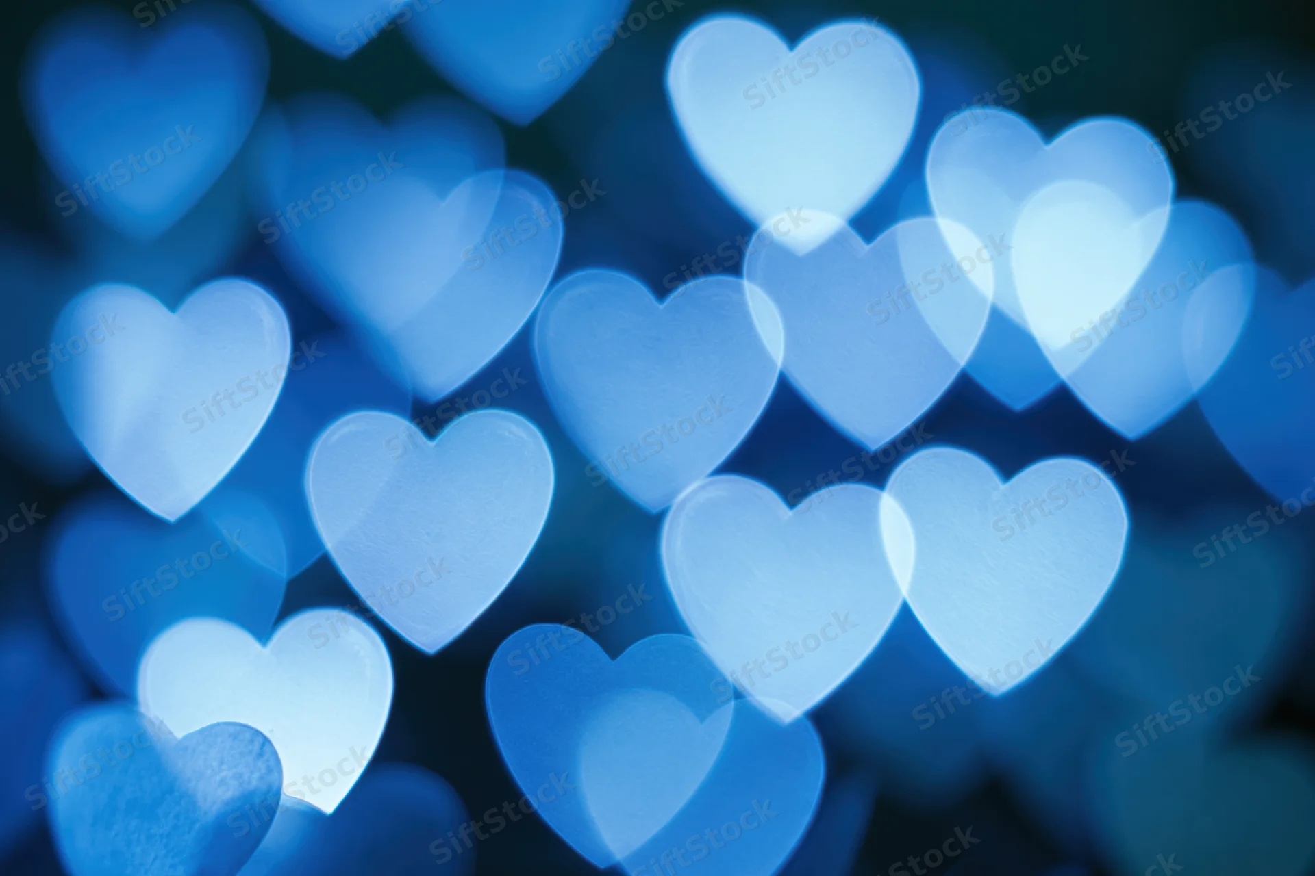 Heart-shaped bokeh lights scattered across a dark blue background
