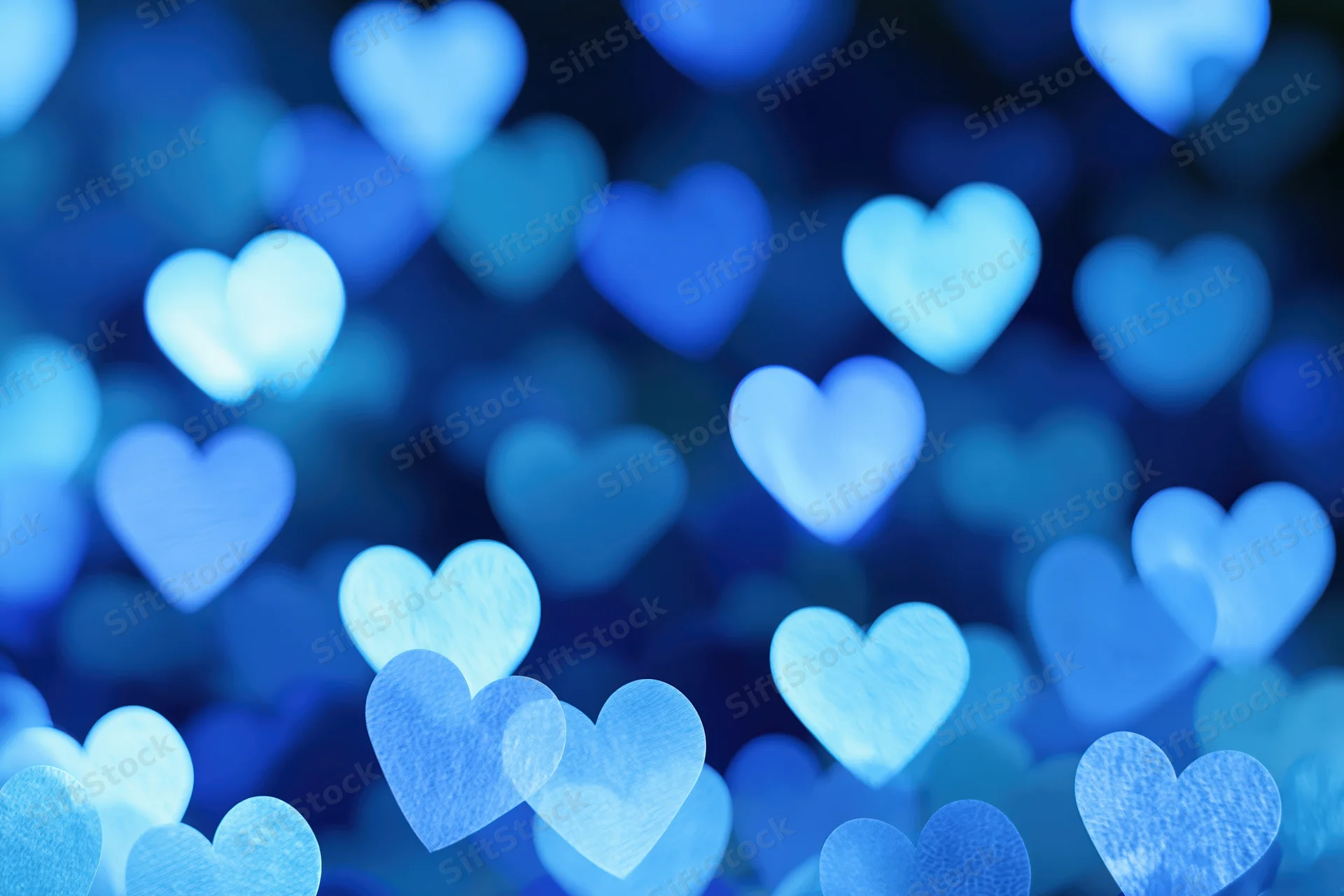 Heart-shaped bokeh lights scattered across the frame in soft blue glow