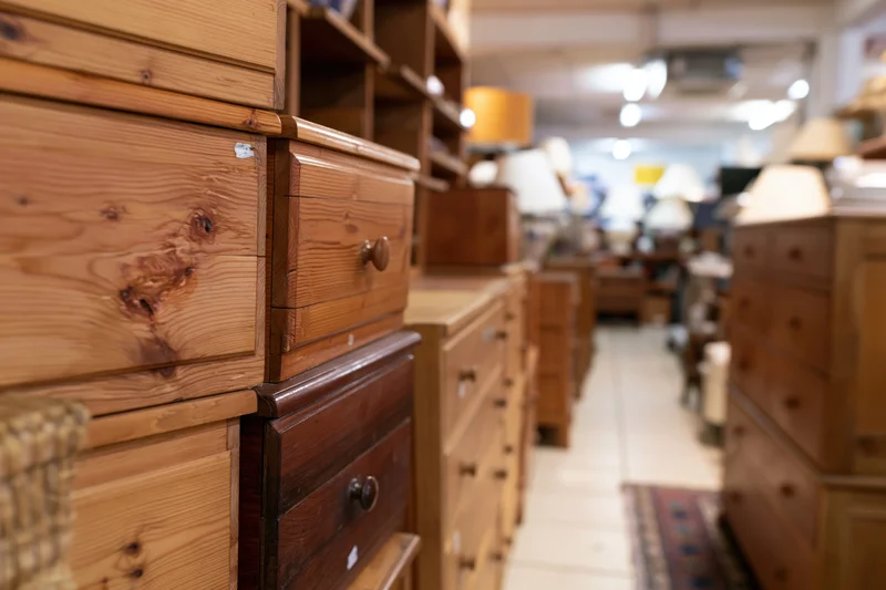Wooden drawers and chests arranged in rows inside a secondhand furniture shop