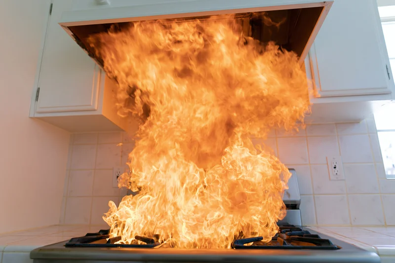 Large flames erupting from gas stove in kitchen interior