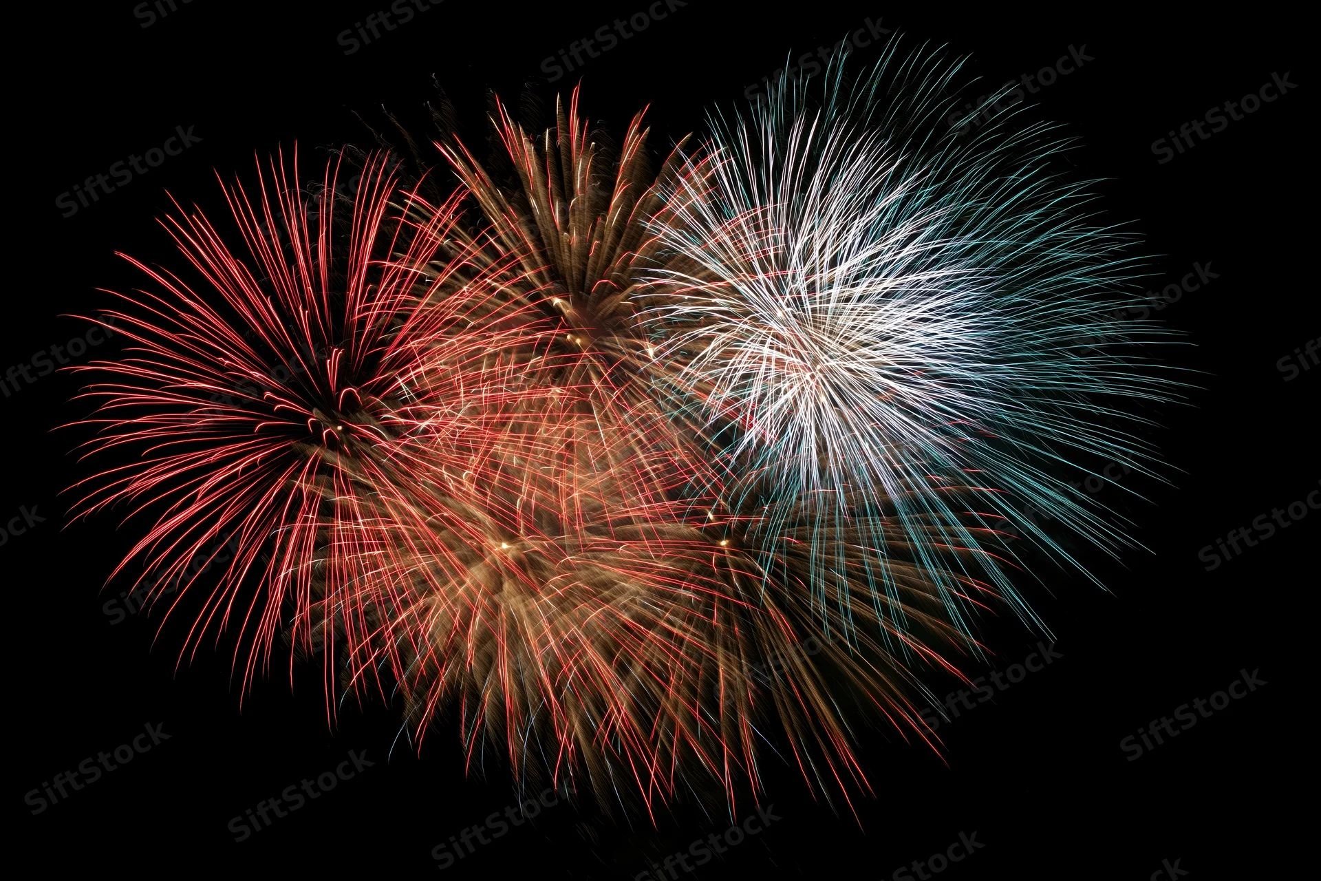 Fireworks bursting in red white and blue forming a heart shape in the night sky
