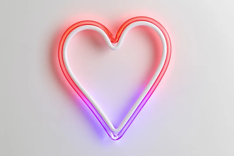 Neon heart outline glowing in red and purple on a white background