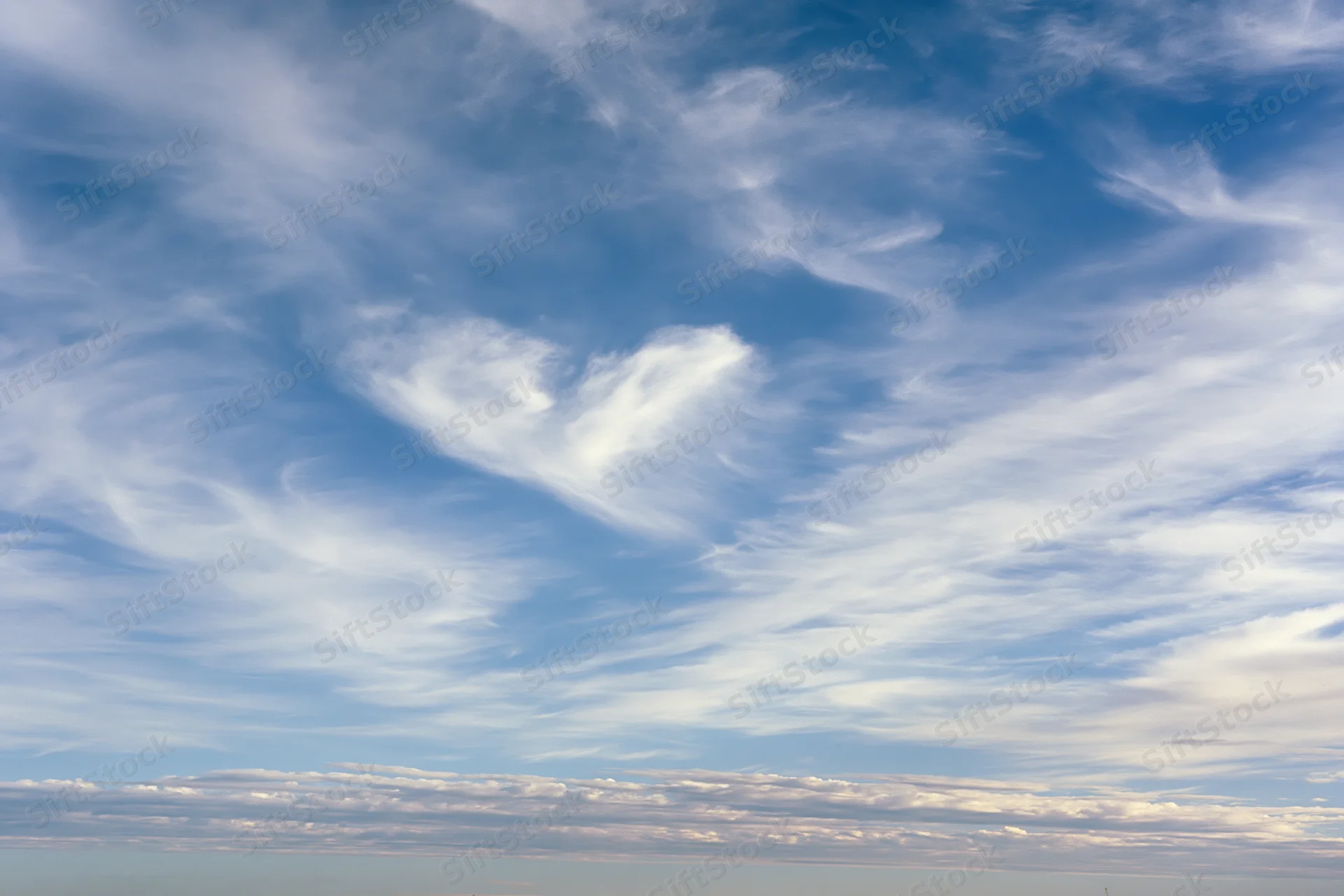Open sky with scattered wispy cirrus clouds during daytime