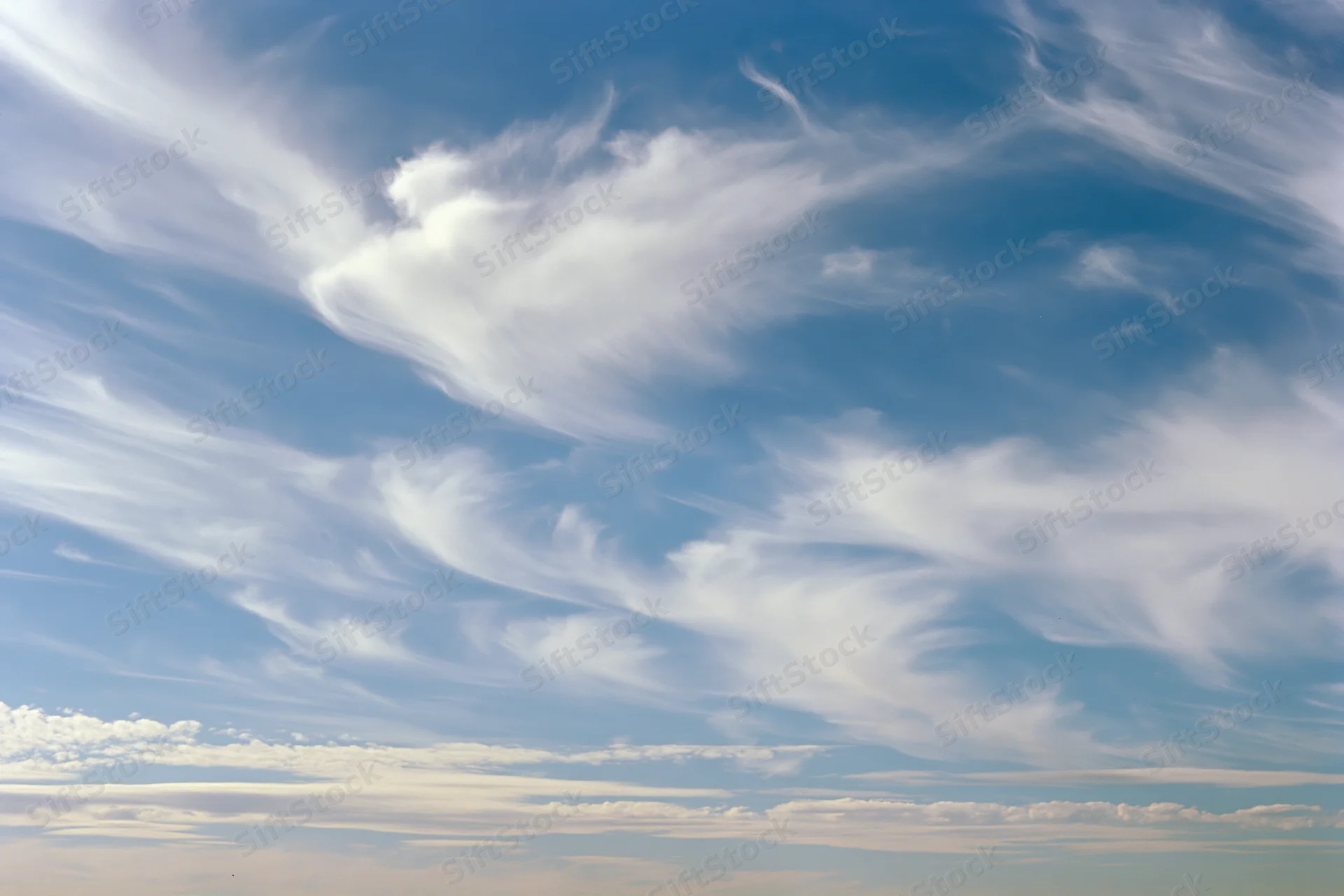 Open sky with scattered wispy cirrus clouds during daytime