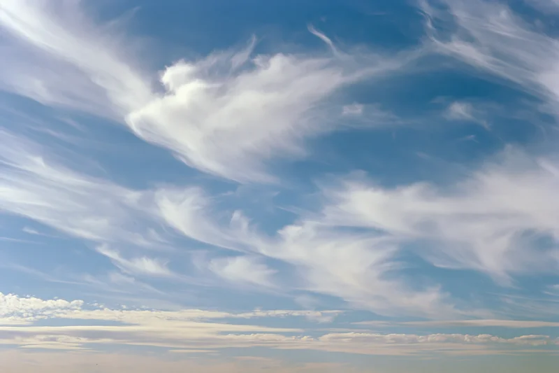 Open sky with scattered wispy cirrus clouds during daytime