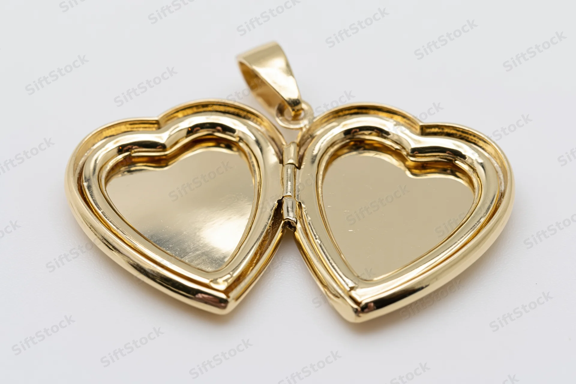 Open gold heart-shaped locket pendant lying flat with both halves visible on white background