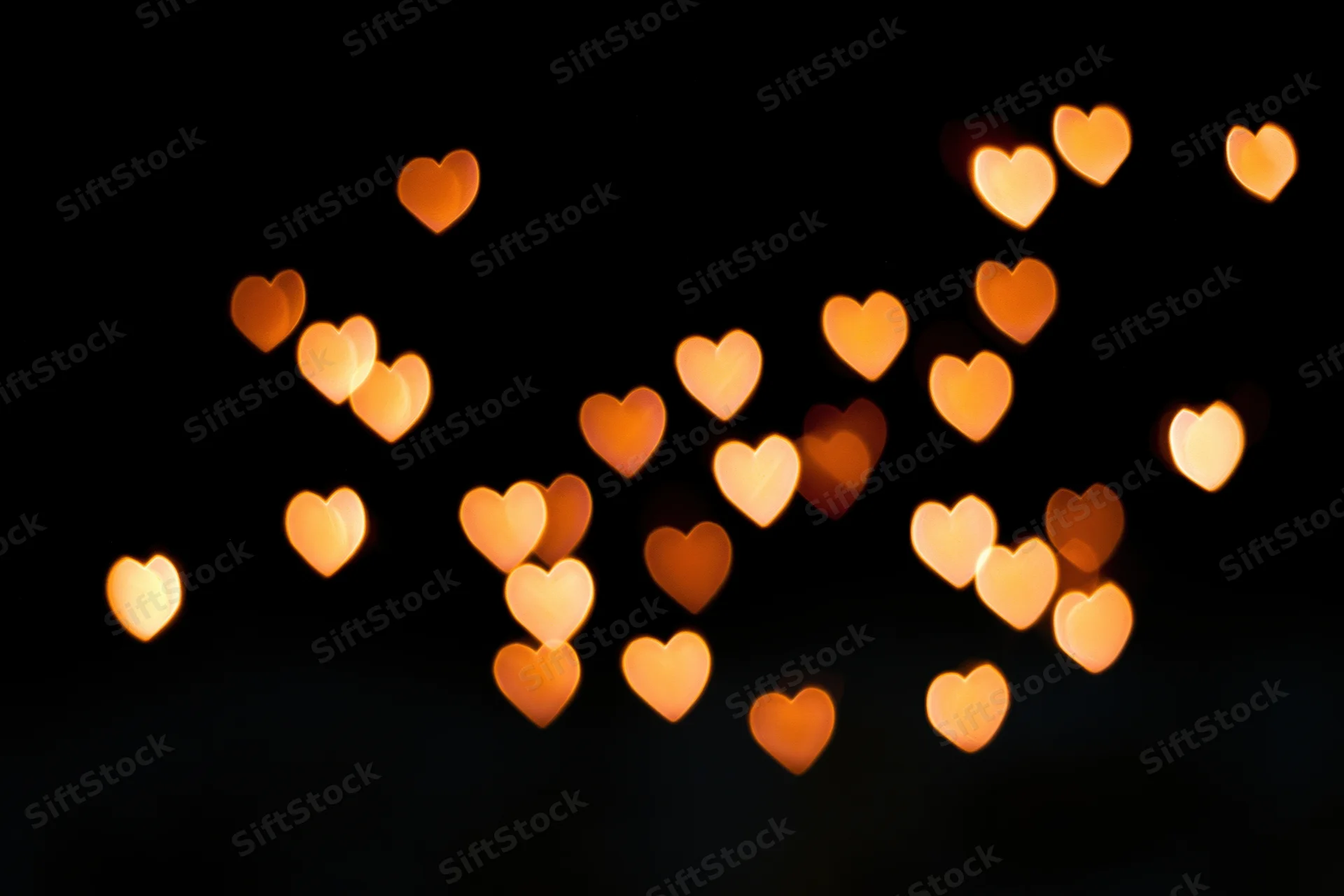 Heart-shaped bokeh lights glowing softly against a dark background