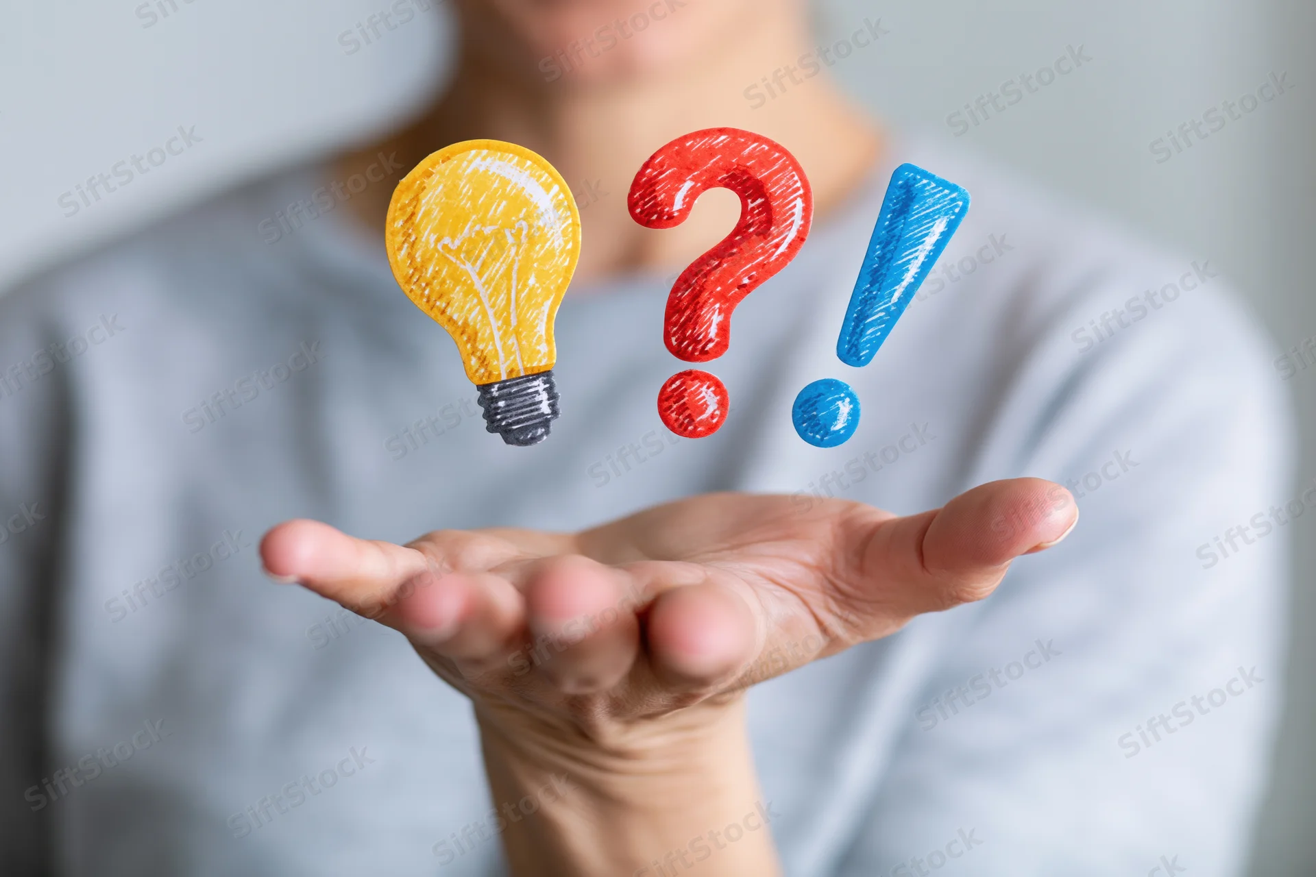 Woman holding open palm with floating lightbulb, question mark and exclamation mark above it