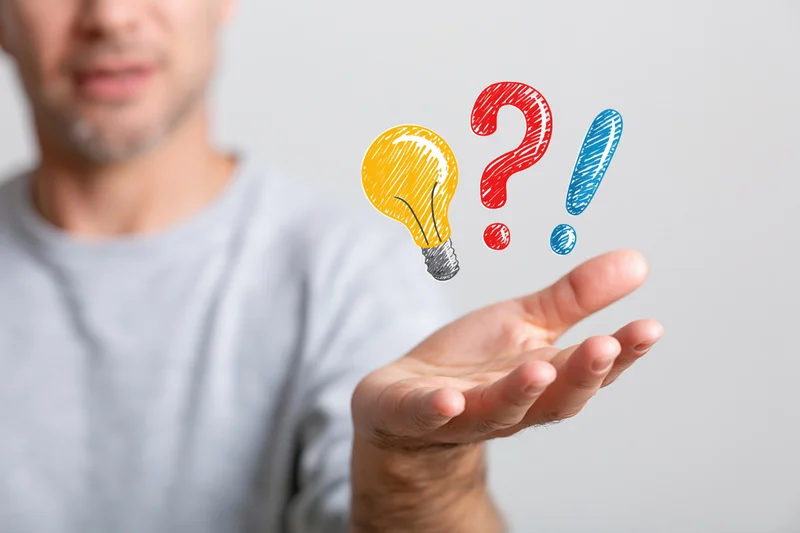 Man holding open palm with floating lightbulb and question and exclamation marks above it