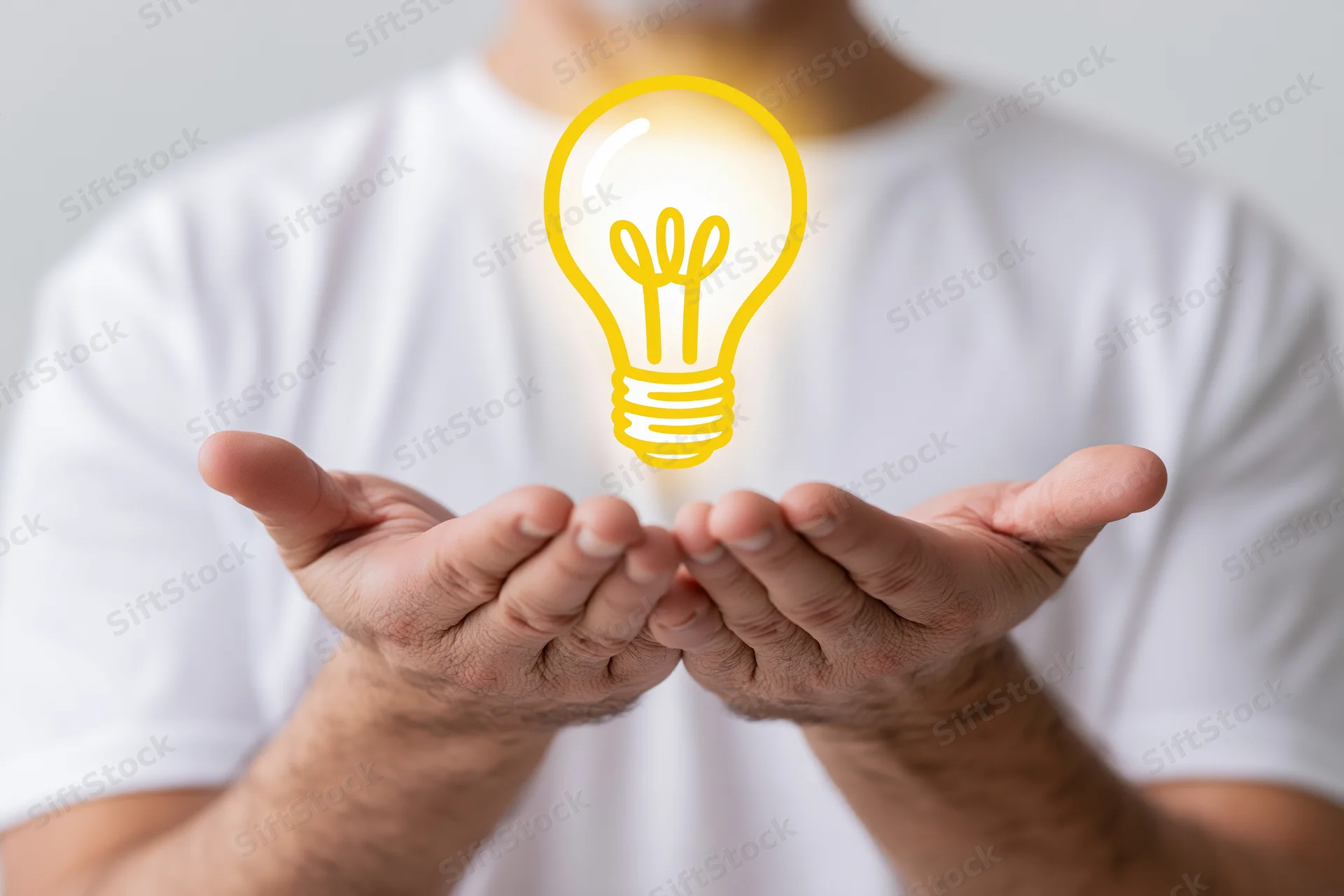 Man holding cupped hands with glowing yellow lightbulb hovering above them