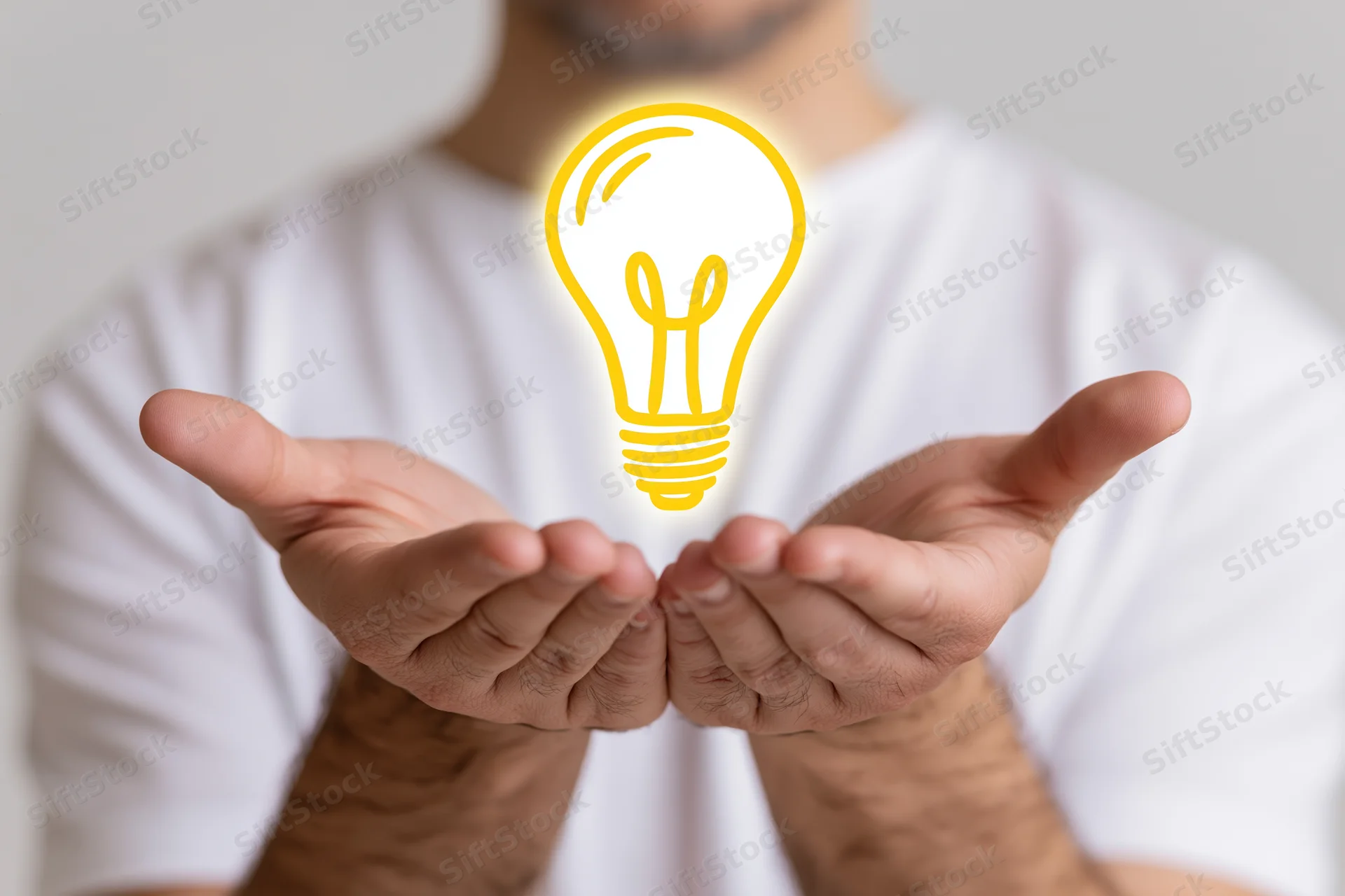 Man holding glowing lightbulb symbol in cupped hands